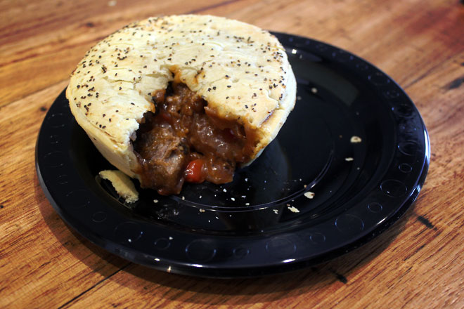 Meat pie with one slice cut out to expose the yummy stuffing.