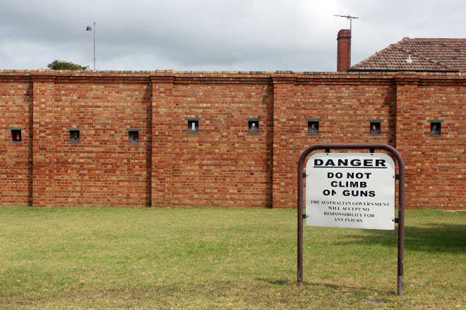 Sign that says "Do not climb the guns" and a nice brick wall for the museum