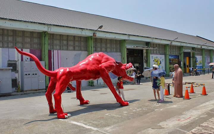 Life-size red monster and man statue.